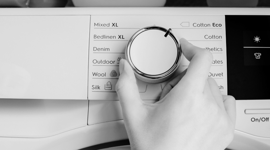 person choosing a drying cycle on their tumble dryer